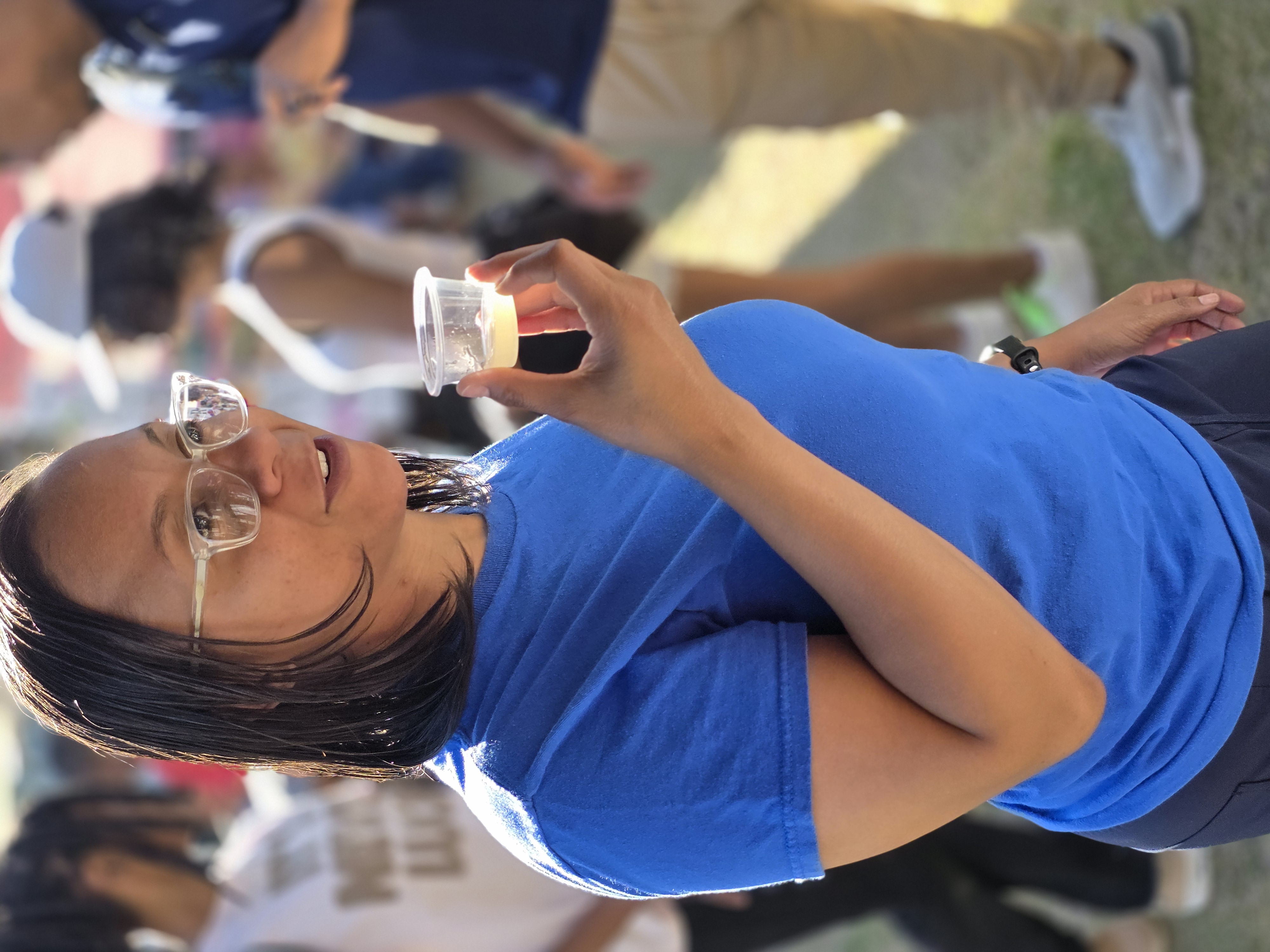 Customer getting ready to taste a fresh juice sample at the market